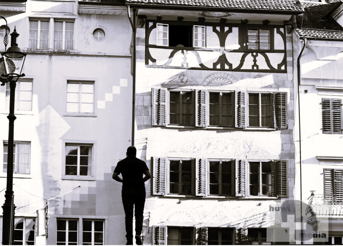 Silhouette einer Person vor historischer Fachwerk-Fassade in der Luzerner Altstadt, Schwarz-Weiss