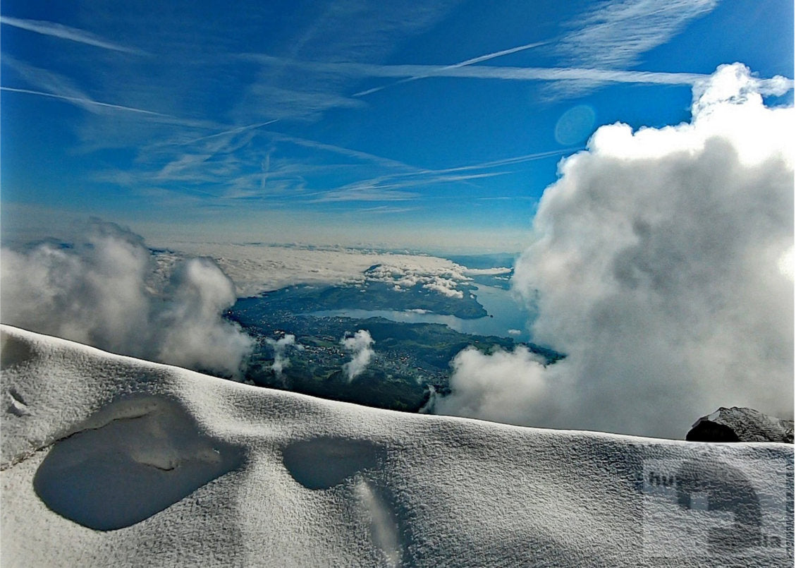 Blick vom Pilatus-Gipfel über Schnee und Wolken auf den Vierwaldstättersee im Winter